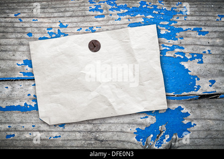 Empty paper ad hanging on vintage wooden wall with blue paint Stock Photo
