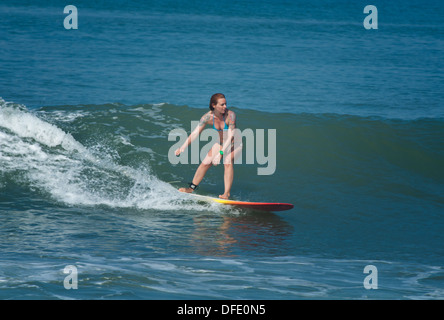 Young woman surfing a wave in Bali, Indonesia. Stock Photo