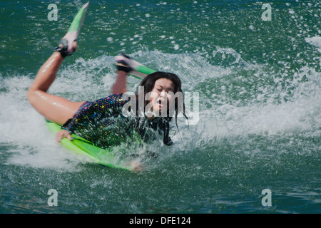 Young woman surfing a wave in Bali, Indonesia. Stock Photo