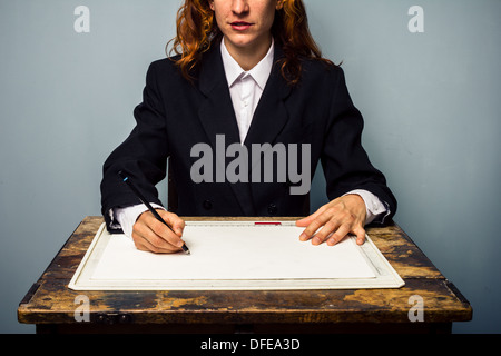Young businesswoman is sitting at a desk working on drawing board Stock Photo