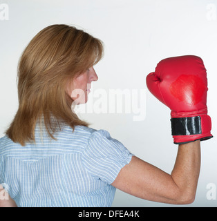 Woman wearing a red boxing glove in fighting mood Stock Photo