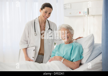 Portrait of doctor and aging patient in hospital room Stock Photo