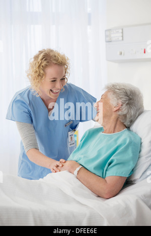 Nurse and senior patient talking in hospital room Stock Photo