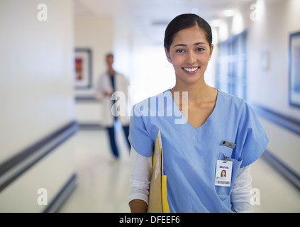 Portrait of smiling nurse in hospital corridor Stock Photo