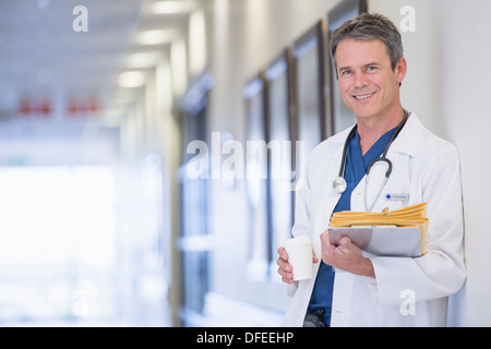 Portrait of smiling doctor in hospital corridor Stock Photo