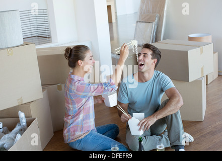 Couple eating Chinese take out food in new house Stock Photo