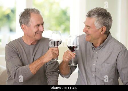 Senior men toasting wine glasses Stock Photo