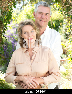 Portrait of smiling senior couple hugging outdoors Stock Photo