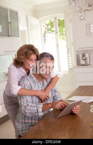 Senior couple using digital tablet in kitchen Stock Photo