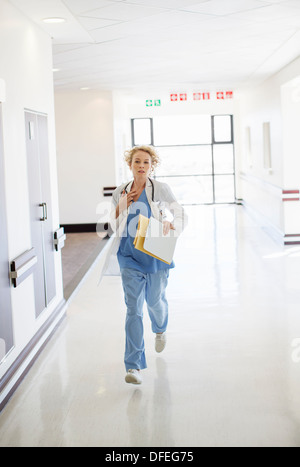 Doctor rushing down hospital corridor Stock Photo