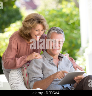 Senior couple using digital tablet on patio Stock Photo