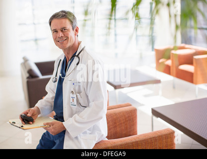 Portrait of smiling doctor in hospital lobby Stock Photo