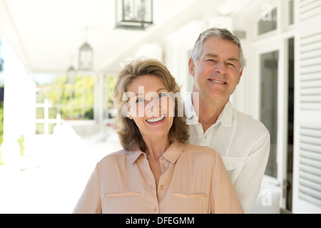 Portrait of senior couple smiling on porch Stock Photo
