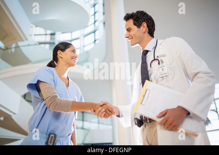 Doctor and nurse handshaking in hospital Stock Photo