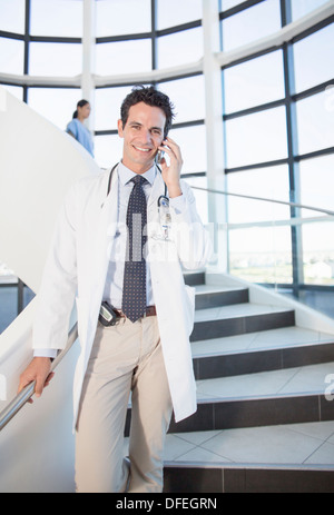 Doctor talking on cell phone in hospital Stock Photo