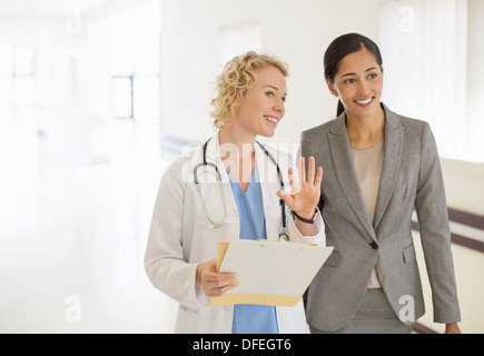 Doctor and businesswoman talking in hospital corridor Stock Photo