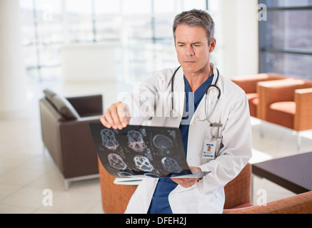 Doctor viewing head x-rays in hospital Stock Photo