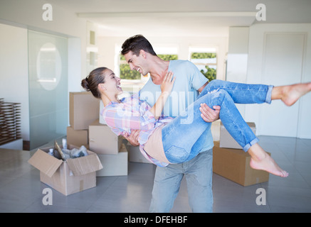 Man carrying girlfriend in new house Stock Photo