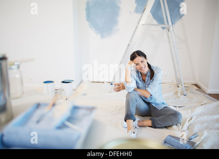 Portrait of woman surrounded by paint supplies Stock Photo