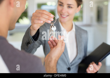 Realtor giving man house keys Stock Photo