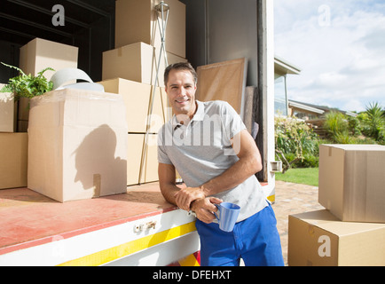 Portrait of man leaning on back of moving van Stock Photo