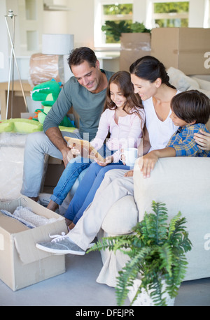 Family looking at picture frame on sofa among cardboard boxes Stock Photo