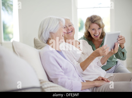 Older women using digital tablet on sofa Stock Photo