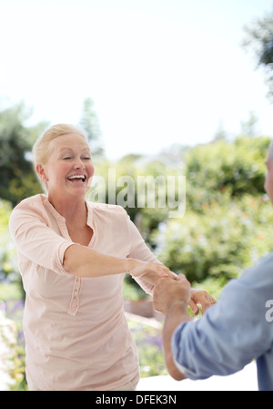 Senior couple dancing on patio Stock Photo