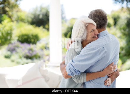 Senior couple hugging on patio Stock Photo