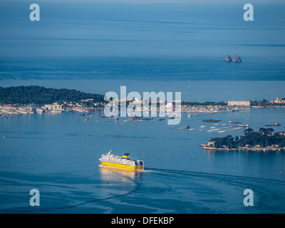 Ferry leaves the harbour of Toulon to Corsica with the Isthme of Sablettes in la Seyne Sur Mer as background Stock Photo