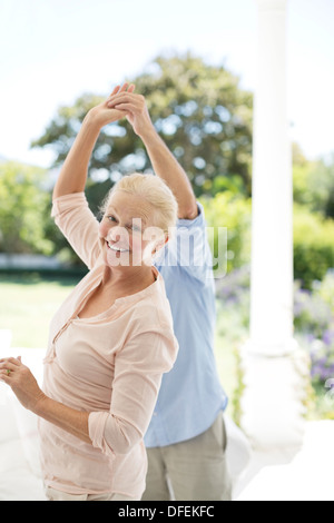 Senior couple dancing on patio Stock Photo
