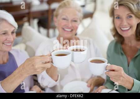 Senior women toasting coffee cups Stock Photo