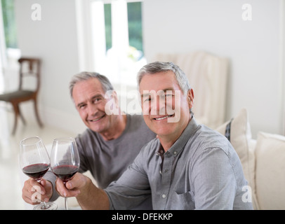 Portrait of senior men toasting wine glasses Stock Photo