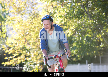 Senior man riding bicycle in park Stock Photo