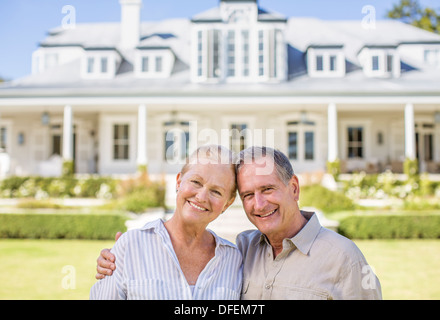 Portrait of smiling senior couple in front of house Stock Photo