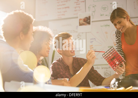Business people looking at cube in meeting Stock Photo