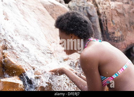 Woman playing in waterfall