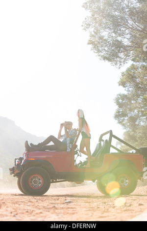 Couple relaxing in sport utility vehicle on dirt road Stock Photo