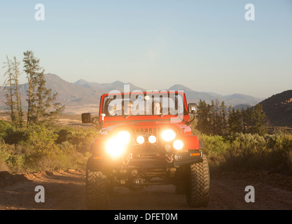 Couple driving sport utility vehicle on dirt road Stock Photo