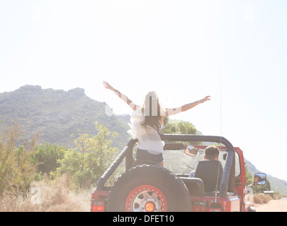 Woman standing in sport utility vehicle Stock Photo