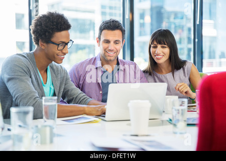 Business people using laptop in meeting Stock Photo