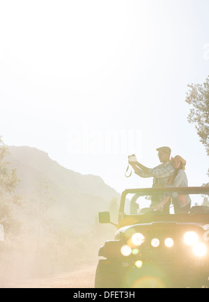 Couple with digital camera in sport utility vehicle Stock Photo