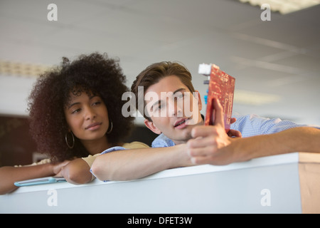 Business people examining circuit board in office Stock Photo