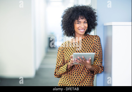 Portrait of woman using digital tablet in office