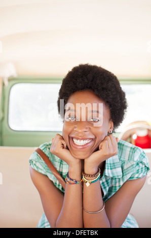 Portrait of smiling woman in back seat of camper van