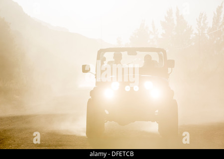 Sport utility vehicle driving on dirt road Stock Photo