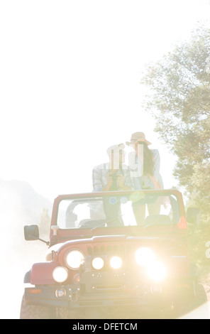 Couple standing in sport utility vehicle Stock Photo