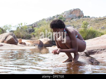 Woman cupping water in river