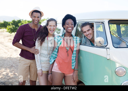 Friends laughing by camper van Stock Photo
