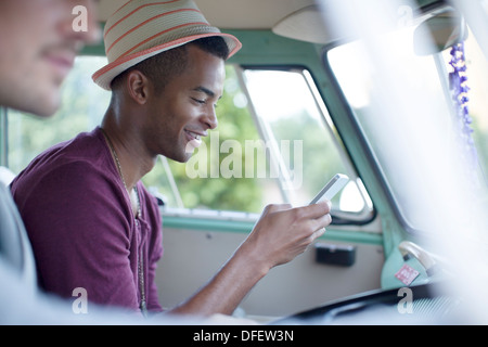 Man using cell phone in camper van Stock Photo